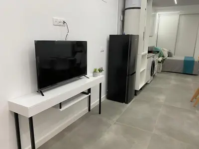 Una televisión o centro de entretenimiento en Alba Home , junto al estadio fútbol y Ribera