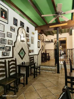 Un restaurante o sitio para comer en La Casa del Gallo Alojamientos by Taberna Bolero
