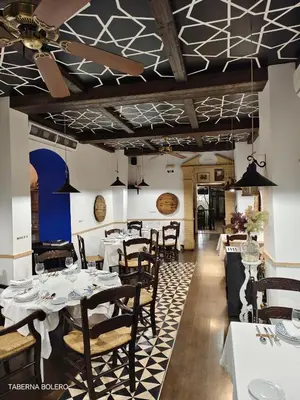 Un restaurante o sitio para comer en La Casa del Gallo Alojamientos by Taberna Bolero