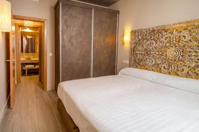Cama o camas de una habitación en Apartamentos Sevilla Este by QHotels