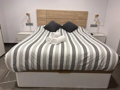 Cama o camas de una habitación en Apartamento espacioso de diseño a 3 min RENFE con Parking Privado