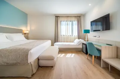 Cama o camas de una habitación en Occidental Sevilla Viapol