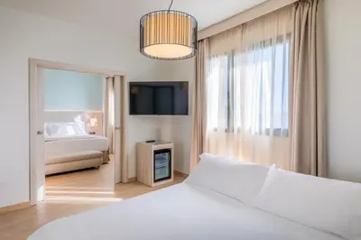 Cama o camas de una habitación en Occidental Sevilla Viapol